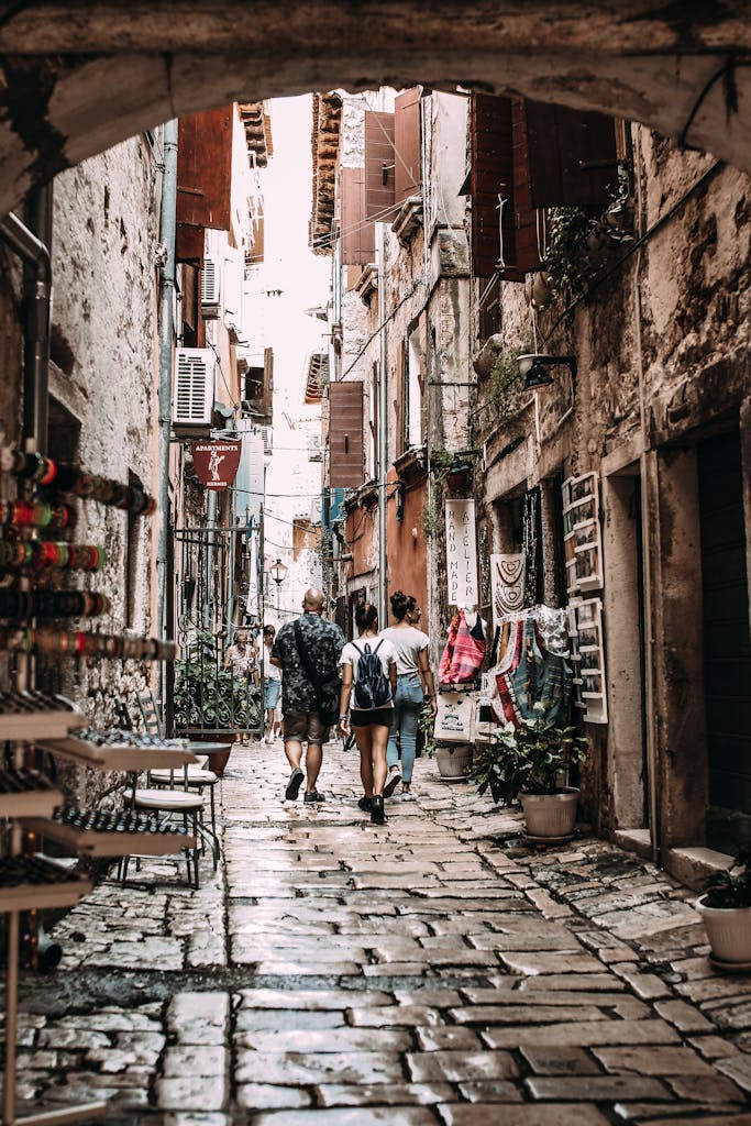 People walking on narrow street between residential buildings